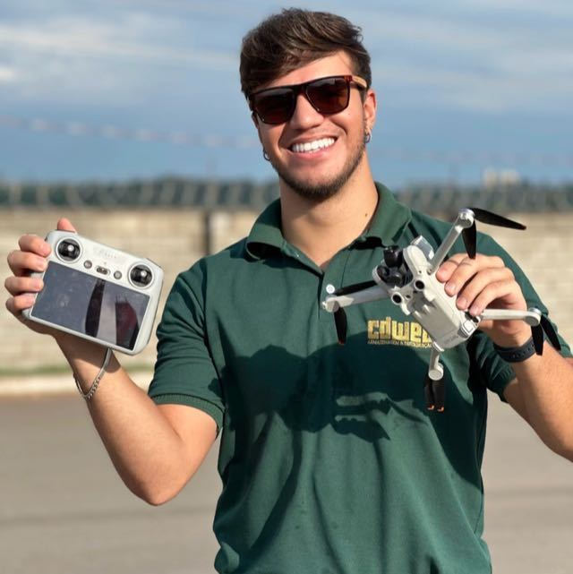 Professor Theo, piloto de drone da Expert Publicidade, segurando o drone e o controle